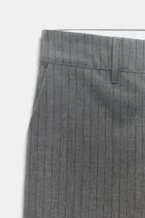 Pantalón de vestir de tiro bajo con diseño de raya diplomática. Presenta corte recto, trabillas para cinturón, bolsillos laterales y cierre frontal con cremallera, botón y ganchos metálicos.