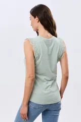Musculosa de algodón color azul con detalles de broderie calado en los hombros, de cuello redondo y corte clásico.