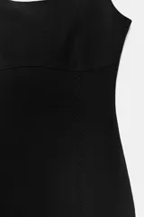 Vestido midi negro, entallado, con escote en pico y tirantes anchos. Presenta detalle de costuras verticales a tono que simulan entredós.