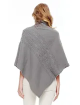 Poncho tejido color crema, con cuello polera y diseño trenzado diagonal en el frente. Presenta un corte asimétrico en el ruedo.