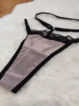 Tanga de microtul color tostado con detalles de encaje negro en la parte superior y tiras elásticas regulables.