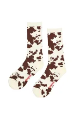 Medias de caña larga con estampado de manchas de vaca en color marrón y crema. Presentan el nombre de la marca bordado en color rojo en la zona del pie.