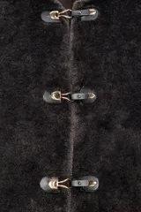 Chaqueta de cuello redondo y manga larga con tejido exterior efecto pelo e interior efecto ante. Presenta bolsillos delanteros de vivo y cierre frontal con alamares metálicos.