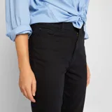 Pantalón de jean negro de corte slim, tiro alto y largo al tobillo.