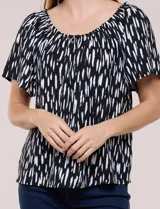 Blusa de poliéster azul con estampado botánico y floral, de silueta holgada y fluido diseño. Cuenta con escote redondo elastizado con frunces y mangas cortas amplias.
