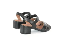 Sandalias de cuero negro con tiras cruzadas en la parte delantera y tira ajustable en el talón. Cuenta con taco bloque bajo y suela flexible.