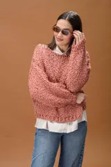 Buzo de tejido de punto grueso con textura, de corte oversize y mangas largas con caída holgada.