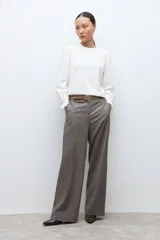 Remera de color blanco con cuello redondo y mangas largas abullonadas que presentan puños con volados.