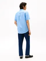 Camisa celeste de lino de manga corta con cuello abotonado y logo bordado en el pecho.