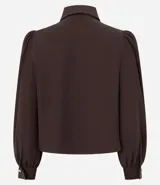 Camisa de crepé color celeste, con cuello inglés, manga larga abullonada y cierre frontal oculto con botón diferenciado en el cuello.