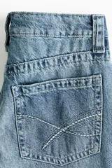 Jean de tiro bajo y corte baggy wide leg, con diseño de cinco bolsillos y lavado desgastado.