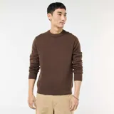 Sweater de punto color marrón, con cuello redondo y diseño liso. Presenta puños y ruedo acanalados.