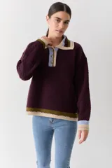 Buzo de lana tipo polo con cuello y cartera de botones en colores contrastantes. Presenta mangas con textura de ochos y terminaciones en puños y ruedo con franjas de colores.