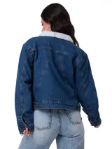 Chaqueta de jean azul con forro interior de corderito blanco, cuello clásico, cierre frontal con botones metálicos y mangas largas con puños abotonados.