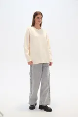 Sweater negro holgado con cuello a la base, manga larga y detalles de mostacillas formando un patrón abstracto.