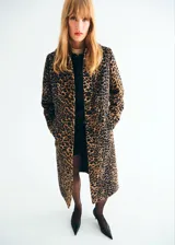 Abrigo largo de corte recto con estampado de leopardo, cuello camisero, cierre frontal con botones y bolsillos laterales. Cuenta con forro interior y manga larga.