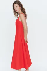 Vestido midi de popelín confeccionado en algodón, color marrón, con escote cuadrado, tirantes anchos y diseño acampanado con paneles godets. Cuenta con cierre lateral de cremallera oculta.