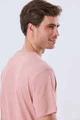 Remera verde pistacho de manga corta y cuello redondo, con diseño gráfico estampado en el frente con inscripciones y tipografías en tonos oscuros y blancos.