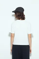 Remera blanca de manga corta con estampa frontal de un personaje con lentes de sol y la frase "Llegué tarde porque no quería venir". Tiene silueta relajada y calce cómodo, con un corte asimétrico en el bajo.