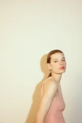 Top de punto color crema, sin mangas, con cuello redondo y corte ajustado.