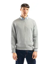 Buzo de punto liso color negro, con cuello redondo y puños y ruedo acanalados. Se lleva sobre una camisa celeste de vestir.