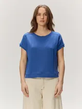 Remera negra de punto fino, con mangas cortas, cuello redondo y corte relajado. Cuenta con costuras verticales decorativas en el frente.