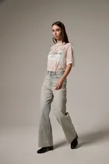 Pantalón jean de tiro alto y corte recto, confeccionado en denim celeste con aplicación de strass en toda la parte frontal.