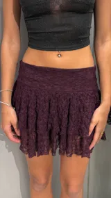 Minifalda de encaje color bordó con diseño de volados y short interior incorporado. Presenta un corte de tiro bajo y una textura delicada.