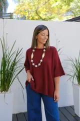 Sweater de punto color bordó, con cuello redondo, manga corta amplia y diseño holgado.