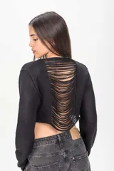 Sweater crop negro de punto con diseño abierto y tiras deshilachadas en la espalda, de manga larga.