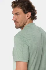 Remera polo de piqué en color azul con estampado de mini print geométrico en toda la prenda. Presenta cuello clásico, cierre frontal con botones personalizados y logo bordado en el pecho.