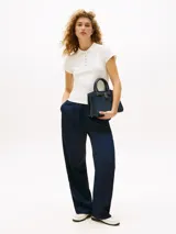 Chomba de manga corta color blanco hueso, con cuello de polo y cartera de cinco botones dorados. Presenta un corte slim y un pequeño logo bordado en el bajo.