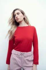 Pantalón rosa pastel con cintura elastizada, bolsillos laterales y cinto con hebilla metálica.