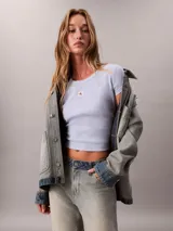 Remera Calvin Klein Jeans de manga corta, color celeste, confeccionada en tejido de punto acanalado con diseño ceñido tipo baby tee y cuello redondo. Presenta una pequeña etiqueta con el logo de la marca centrada en el pecho.