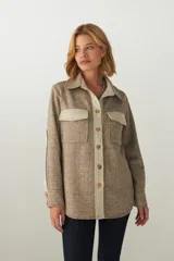 Camisa estilo leñador color marrón con detalles en beige, de manga larga y bolsillos en el frente. Confeccionada en lana fina sin teñir.