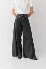 Pantalón de jean azul de tiro alto y corte wide leg súper amplio, con diseño de perneras ancha y terminación desmechada en el ruedo.