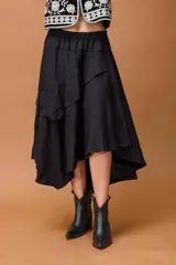Falda negra de corte asimétrico con diseño irregular y volados que aportan movimiento. Presenta cintura elástica y una caída fluida.