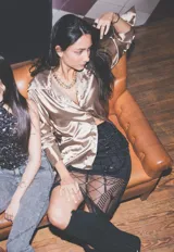 Camisa de satén color tostado, de manga larga, con cuello solapa y cierre frontal con botones.