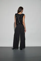 Pantalon negro de corte holgado y estilo cargo, con cintura elástica, bolsillos laterales y terminación ajustada en los tobillos.