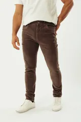 Pantalón de pana color gris topo, corte regular, con cinco bolsillos, cierre con botón y logo bordado.