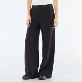 Pantalón de corte ancho y tiro medio, color negro, con detalle de cintura elástica visible estilo bóxer y bolsillos laterales.