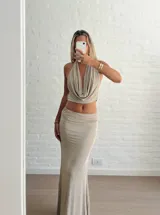Conjunto de dos piezas color beige, compuesto por un top halter con escote drapeado y una falda larga de corte recto y tiro alto.