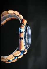 Reloj de pulsera Chenaut modelo Ocean, con caja y malla combinadas en madera de Zebrano africano y acero inoxidable azul. Presenta una esfera azul con subdiales de madera, indicador de fase lunar, fechador y bisel técnico tipo buzo.