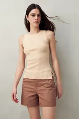 Musculosa negra de tejido de punto acanalado, sin mangas, con cuello redondo y lazos ajustables en los laterales.