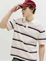 Sweater polo de tejido de punto en color beige, con diseño de rayas horizontales en tonos bordó, azul y celeste. Cuenta con cuello camisero y cartera de tres botones.