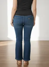 Jean maternal azul lavado, elastizado, de corte flare, con faja de algodón de altura media con elástico ajustable y detalles de tachas cromadas.