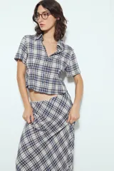 Falda larga de silueta fluida con estampado a cuadros en tonos marrones y beige. La prenda tiene una caída liviana y un calce cómodo.