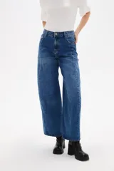 Pantalon de jean estilo barrel con tiro alto y bolsillos laterales. Presenta un corte amplio y relajado en las piernas con un lavado azul clásico.