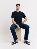 Remera de punto color beige, de manga corta y cuello redondo.