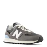 Championes urbanos New Balance modelo 574 Cordura, color gris con detalles en blanco y celeste. Confeccionados en gamuza y malla, cuentan con el logo N característico en los laterales y entresuela con tecnología ENCAP.